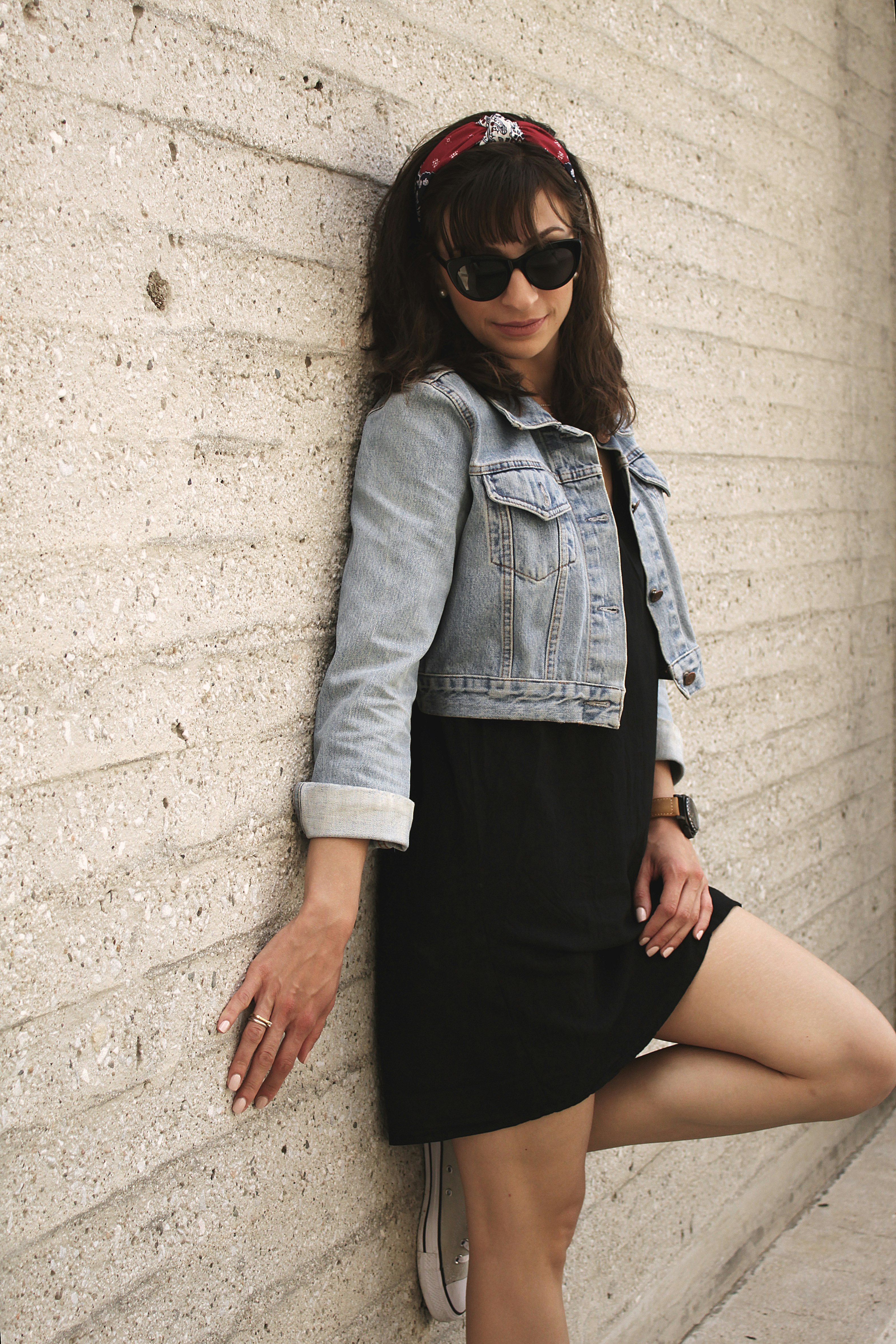 woman leaning on white concrete wall during daytime